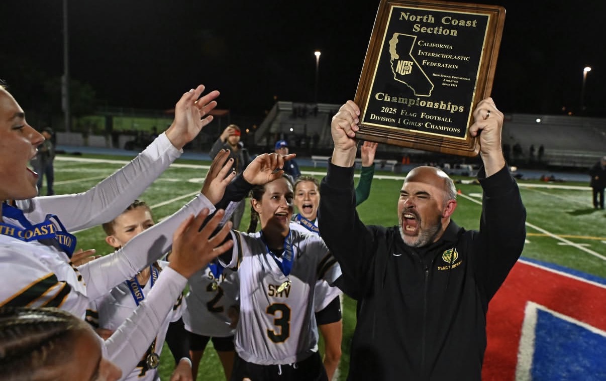 Coach Cochran hoisting the 2025 NCS Division I Girls' Flag Football Championship plaque